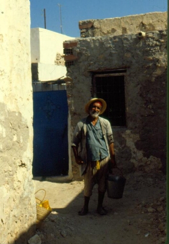 Portrait en pied d'un homme âgé coiffé d'un chapeau de paille dans les rues de la hara Kebira, Djerba, Tunisie